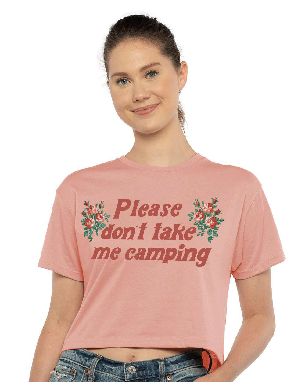 Person wearing a pink t-shirt with text that says “Please don’t take me camping” and floral design.