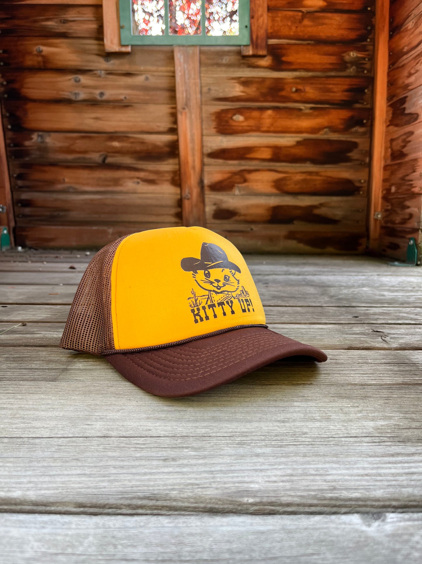 Yellow and brown trucker hat with a cat graphic and 'Kitty Up!' text.