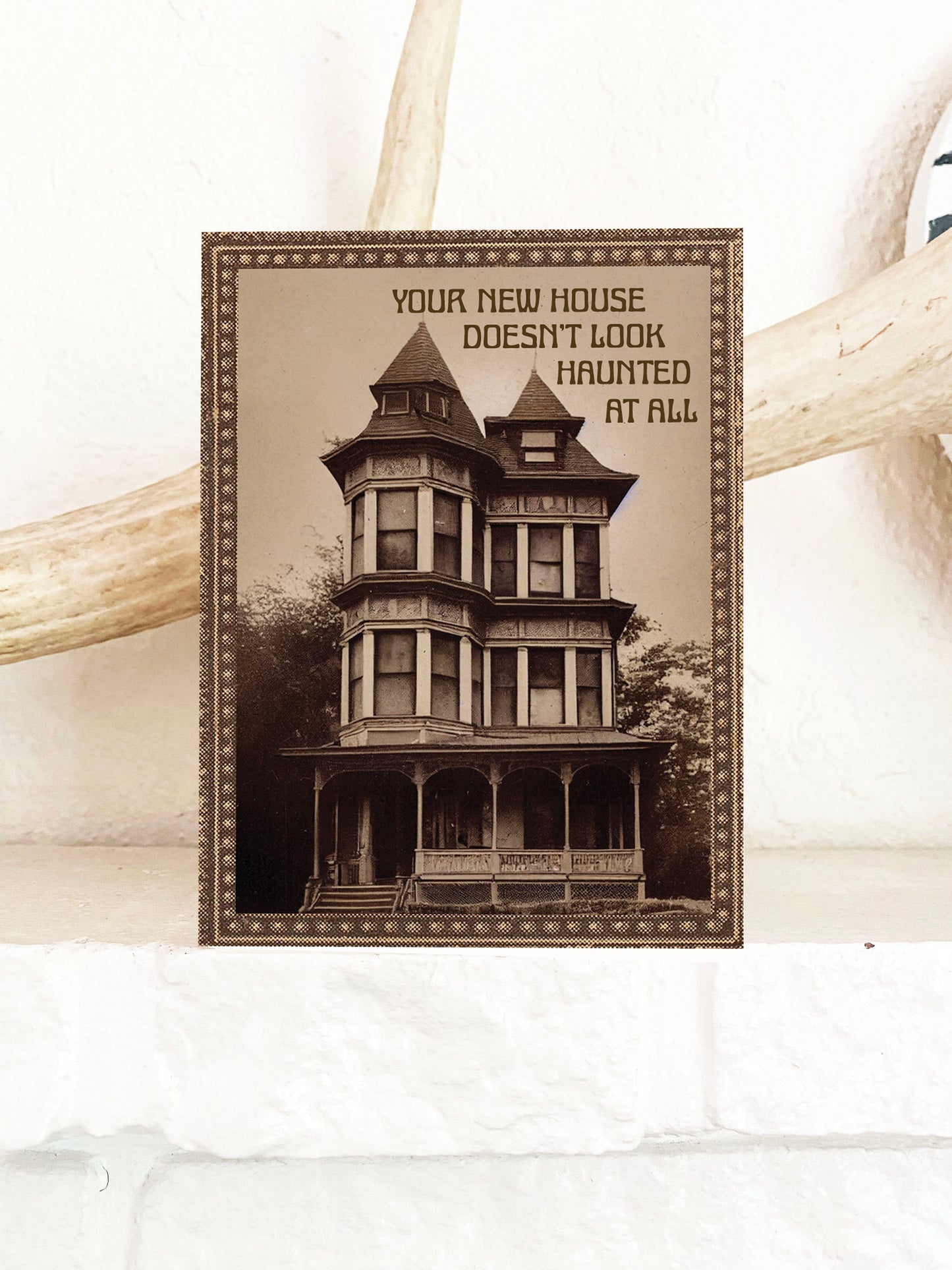 Card with vintage-style house illustration with “Your new house doesn’t look haunted at all” text.