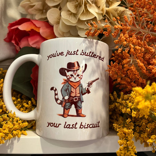 Mug with cowboy cat illustration Buttered your last biscuit text 