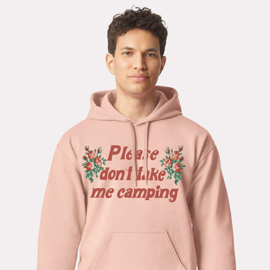 Person wearing a pink hoodie with floral text design on a plain background that says “Please don’t take me camping”