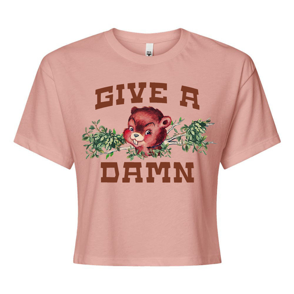 Pink t-shirt with a graphic of a beaver and text 'GIVE A DAMN' on a white background