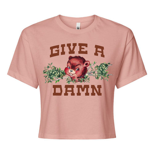 Pink t-shirt with a graphic of a beaver and text 'GIVE A DAMN' on a white background