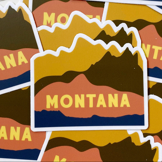 Stickers with 'Montana' text and mountain design on a brown background
