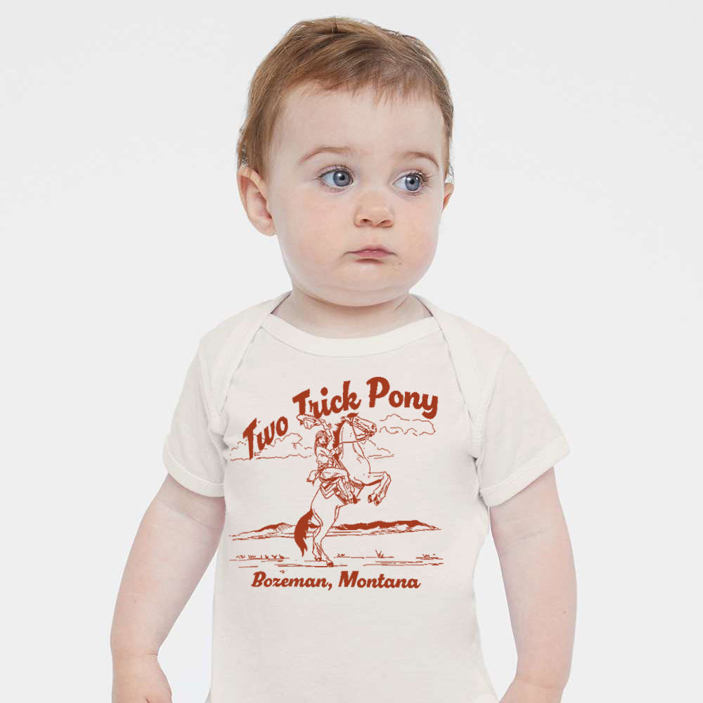 Baby wearing a onesie with 'Two Trick Pony' branding on a white background