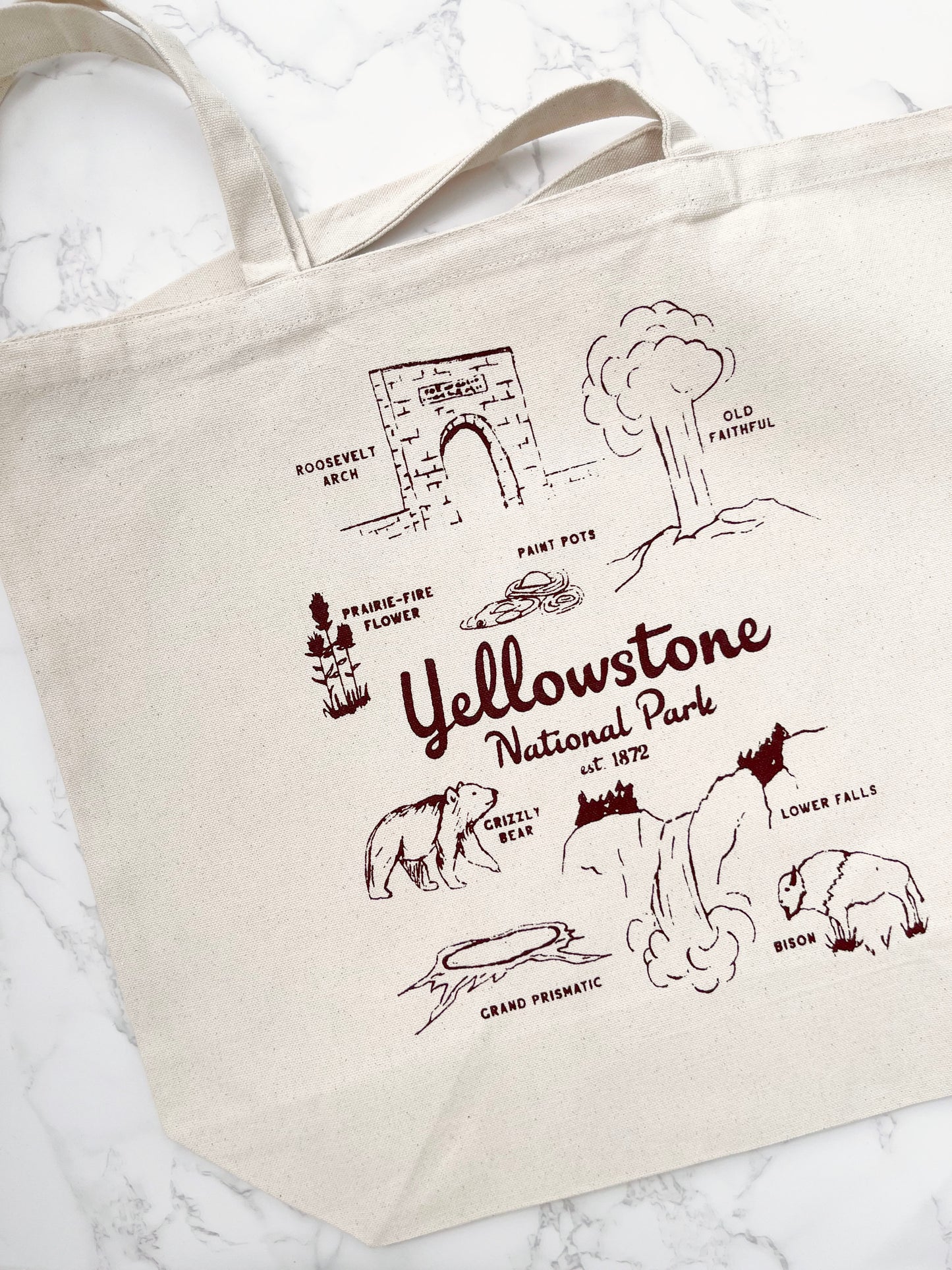 Tote bag with Yellowstone National Park illustrations and text on a white background