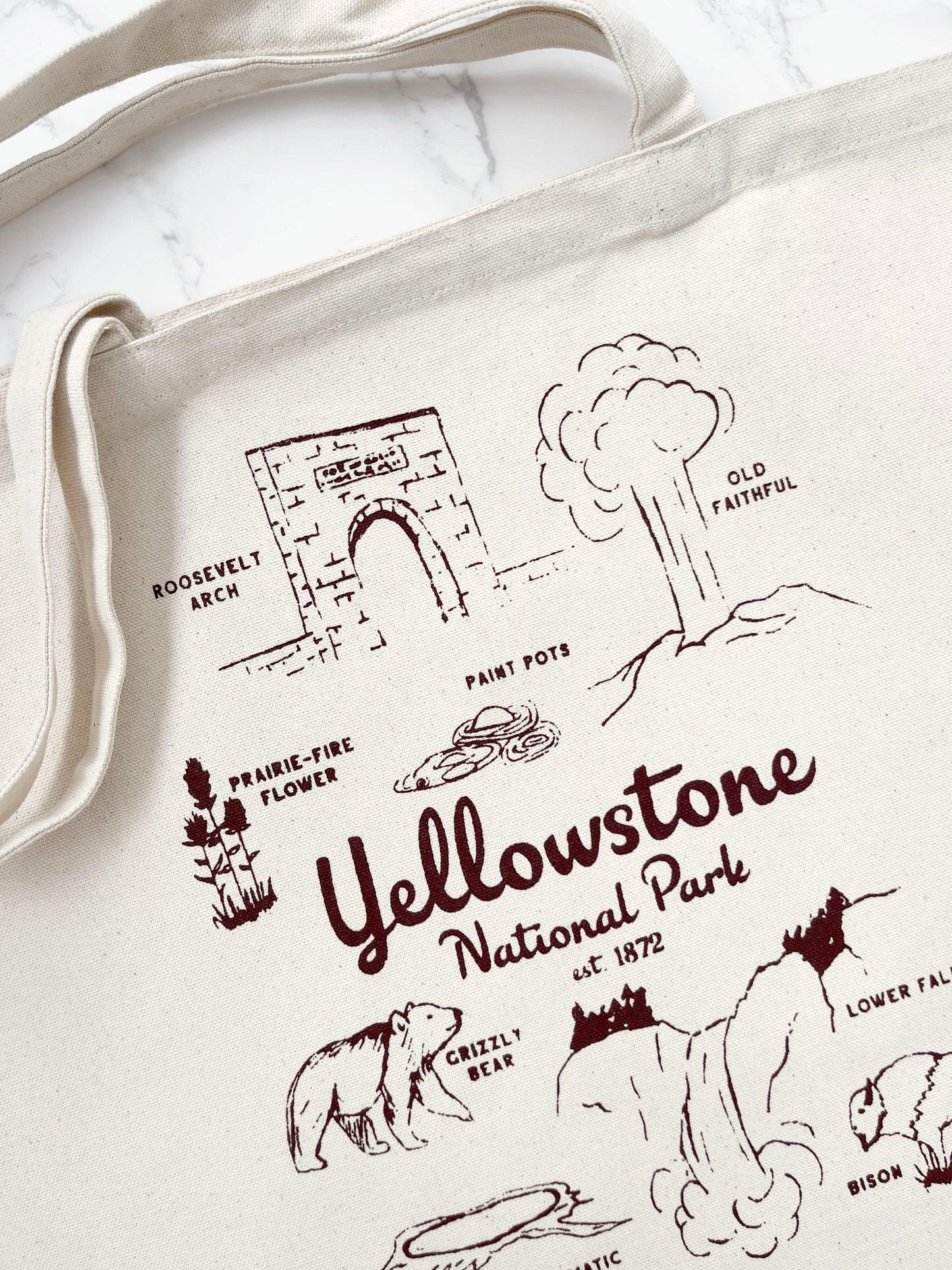 Tote bag with Yellowstone National Park illustrations and text on a white background